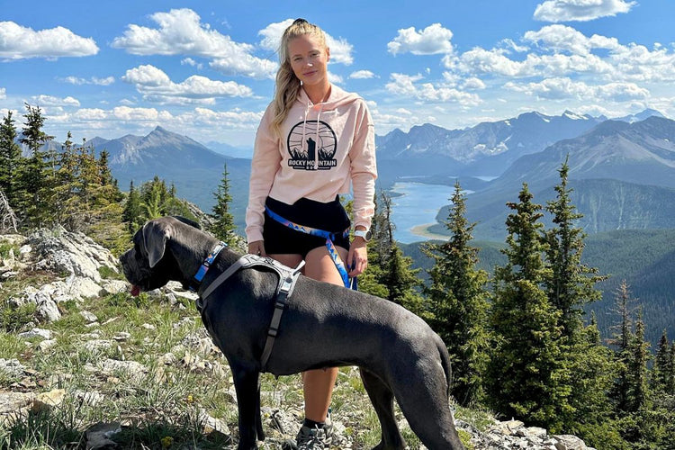 female and dog hiking in mountains sunset