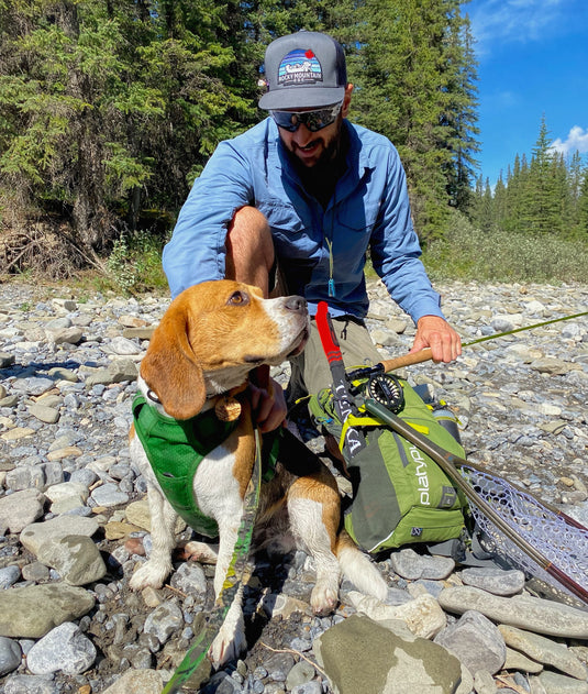 Man with dog fishing wearing an RMD Patch hat